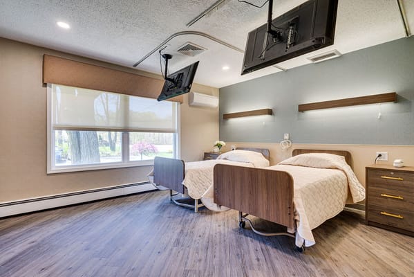 Well-appointed private room with two beds and TVs