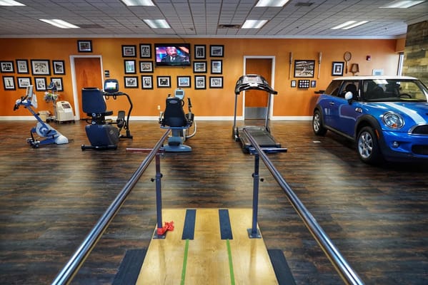 Interior view of a fitness area with exercise equipment and a car