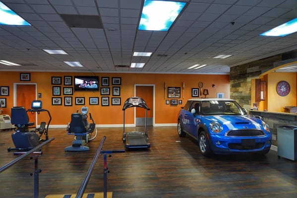 Gym area with fitness equipment and blue car