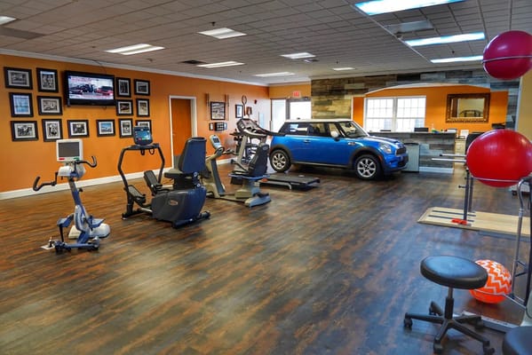 Interior view of a fitness area with equipment and a car