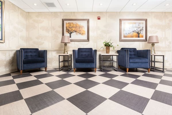 A comfortable lobby area with blue chairs and artwork