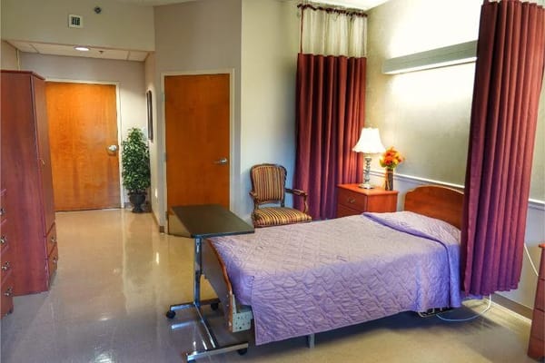 A spacious resident room with a single bed and window