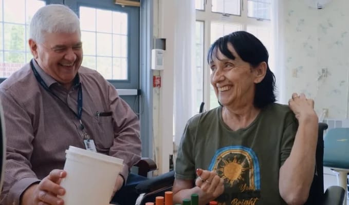 Staff member engaging with a resident in an activity room