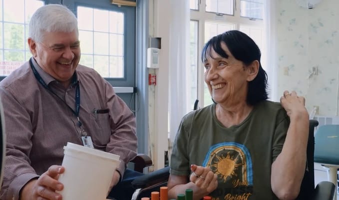 Staff member engaging with a resident in an activity room