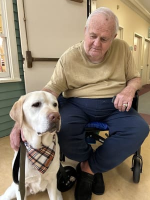 A resident with a service dog in a hallway
