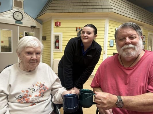 Residents enjoying coffee with staff in a cozy setting
