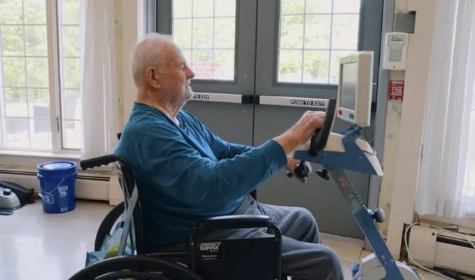 Senior resident using an exercise machine indoors