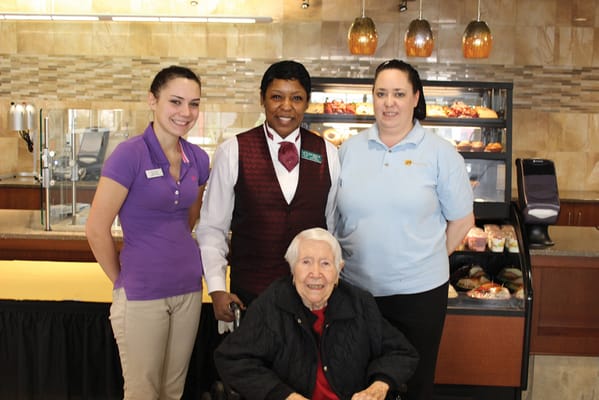 Staff and resident posing together in a dining area