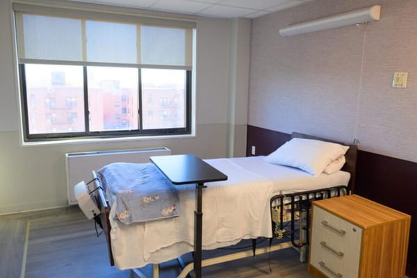 A bright, clean resident room with a bed and window