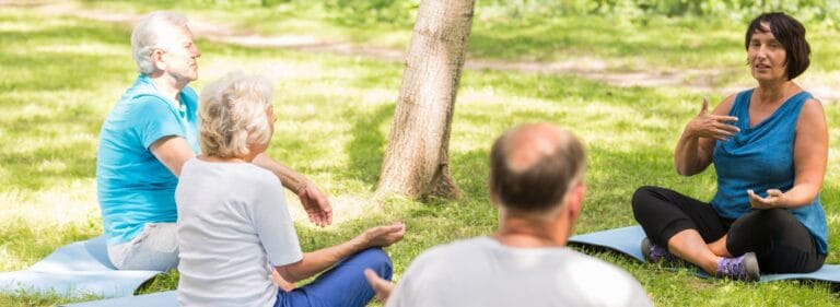 Seniors participating in a yoga session outdoors