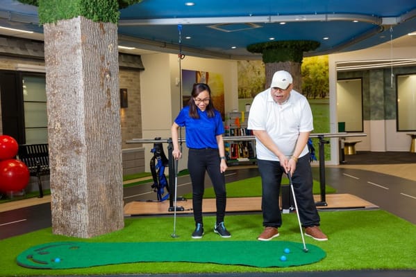 Residents engaging in a therapeutic golf activity indoors