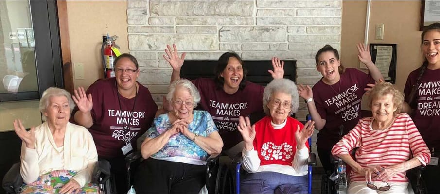 Residents and staff members smiling and waving together