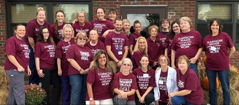 Group photo of staff members in maroon shirts