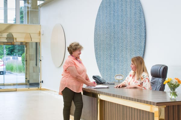 Resident interacting with staff at the front desk