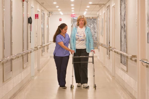Staff assisting a resident in a hallway