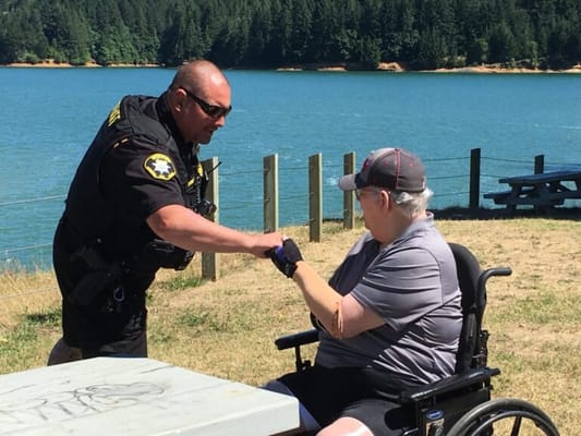 A resident interacting with a staff member by a lake