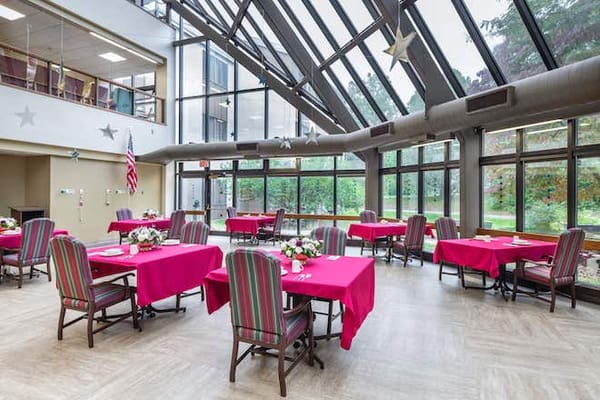 Bright dining room with red tables and outdoor view