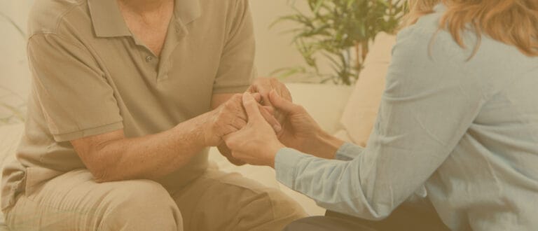 A caregiver holding hands with a senior resident