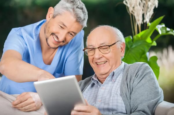 Staff assisting a resident with a tablet
