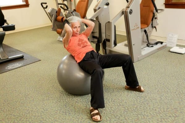 Senior exercising on a stability ball in the fitness area