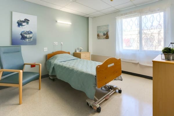 Private resident room with a bed and chair