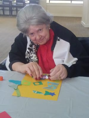 Resident engaged in a crafting activity at a table