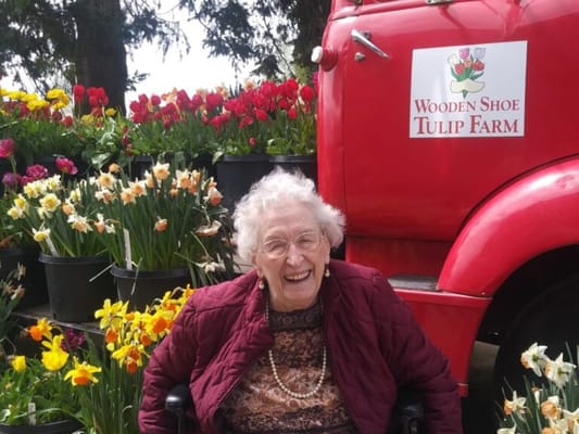 Senior woman smiling among blooming flowers