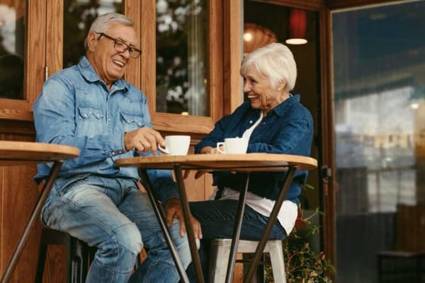 Two seniors enjoying coffee at an outdoor cafe