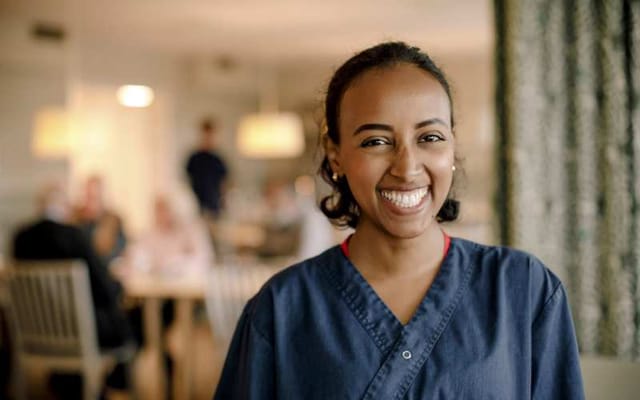 Nurse smiling in an interior setting