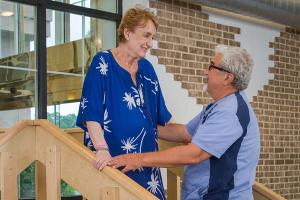 Staff assisting a resident on a staircase