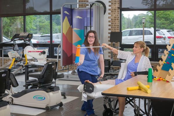 Therapist assisting a resident with rehabilitation exercises