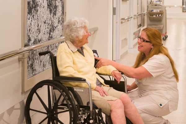 Staff interacting with a resident in a hallway