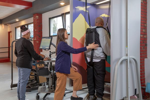 Staff assisting a resident with rehabilitation equipment