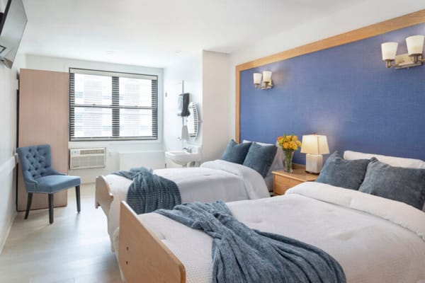 Bright resident room with two beds and modern decor