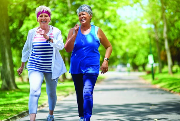 Two senior women jogging in a park