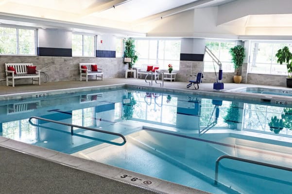 Indoor swimming pool area with lounge chairs