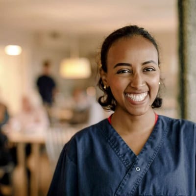 A smiling staff member in a dining area