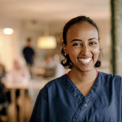 A smiling staff member in a dining area