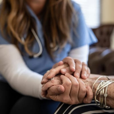 Caregiver holding hands with a resident