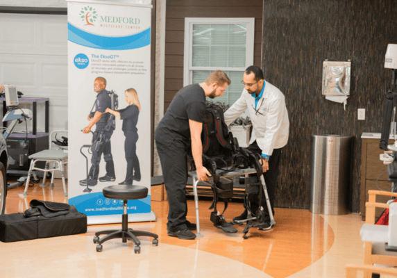 Staff assisting with rehabilitation equipment in an interior space