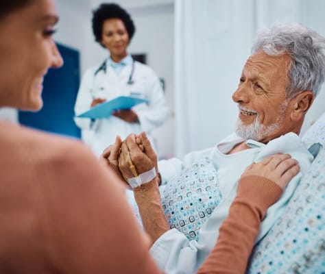A doctor interacting with an elderly patient in a hospital room