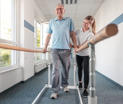 Resident using therapy bars assisted by a staff member