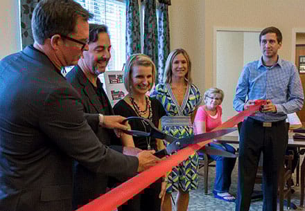 Ribbon cutting ceremony with attendees in the common area