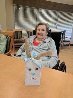 An elderly woman with a handmade Easter decoration