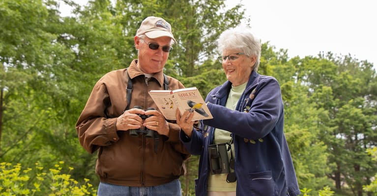 Two residents enjoying a book outside in the garden