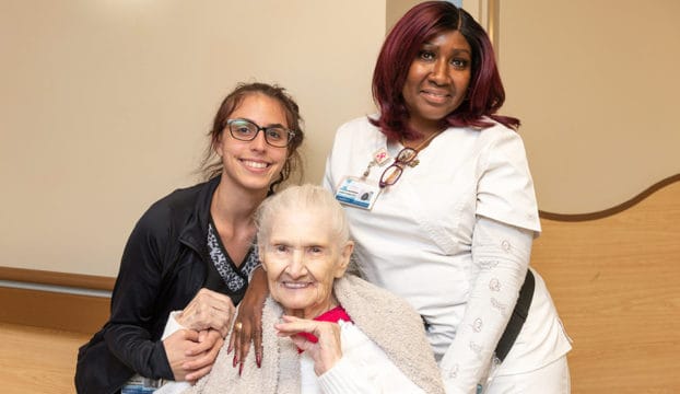 Staff and resident posing together in a shared space