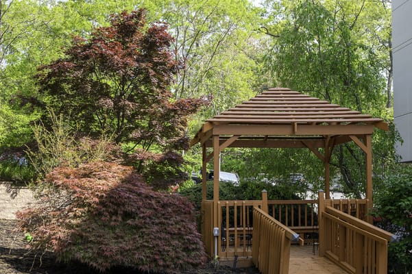 Wooden gazebo surrounded by colorful shrubs
