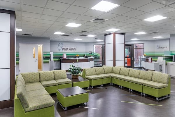 Bright common area with green seating and reception