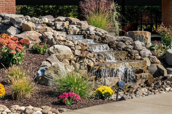 Water feature surrounded by colorful flowers