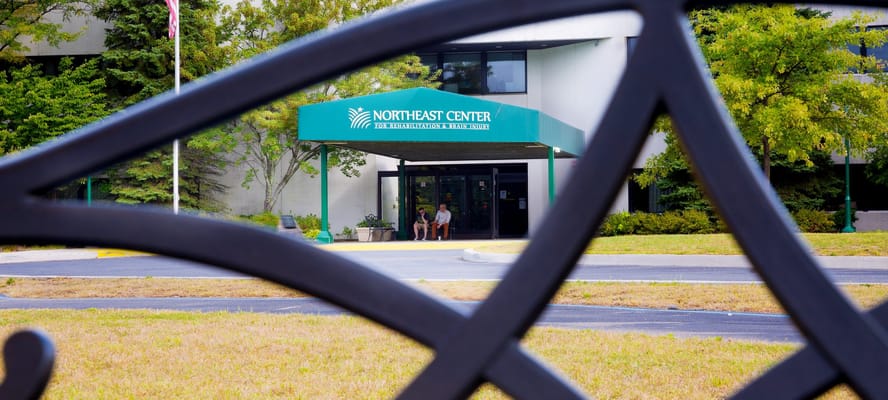 Entrance of Northeast Center with residents sitting outside